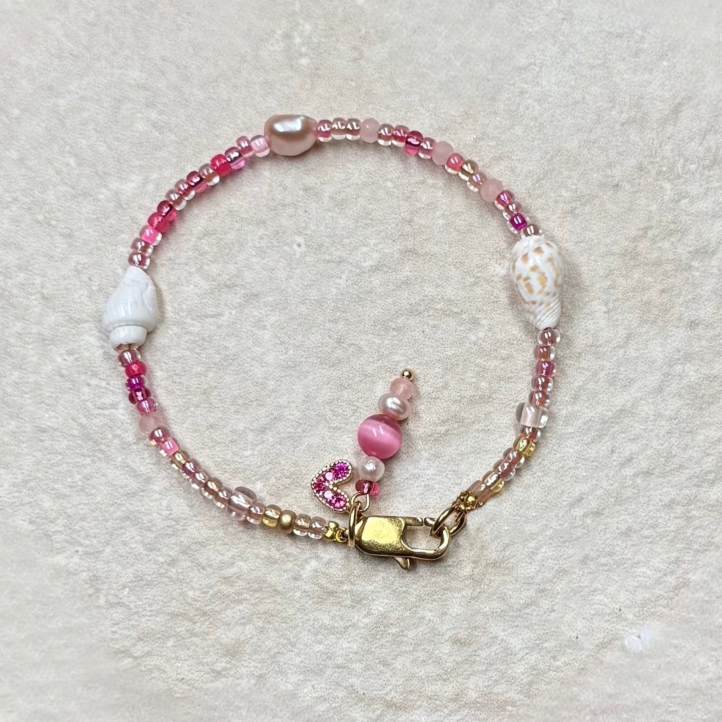 Beaded bracelet with pink and white beads on a light gray background