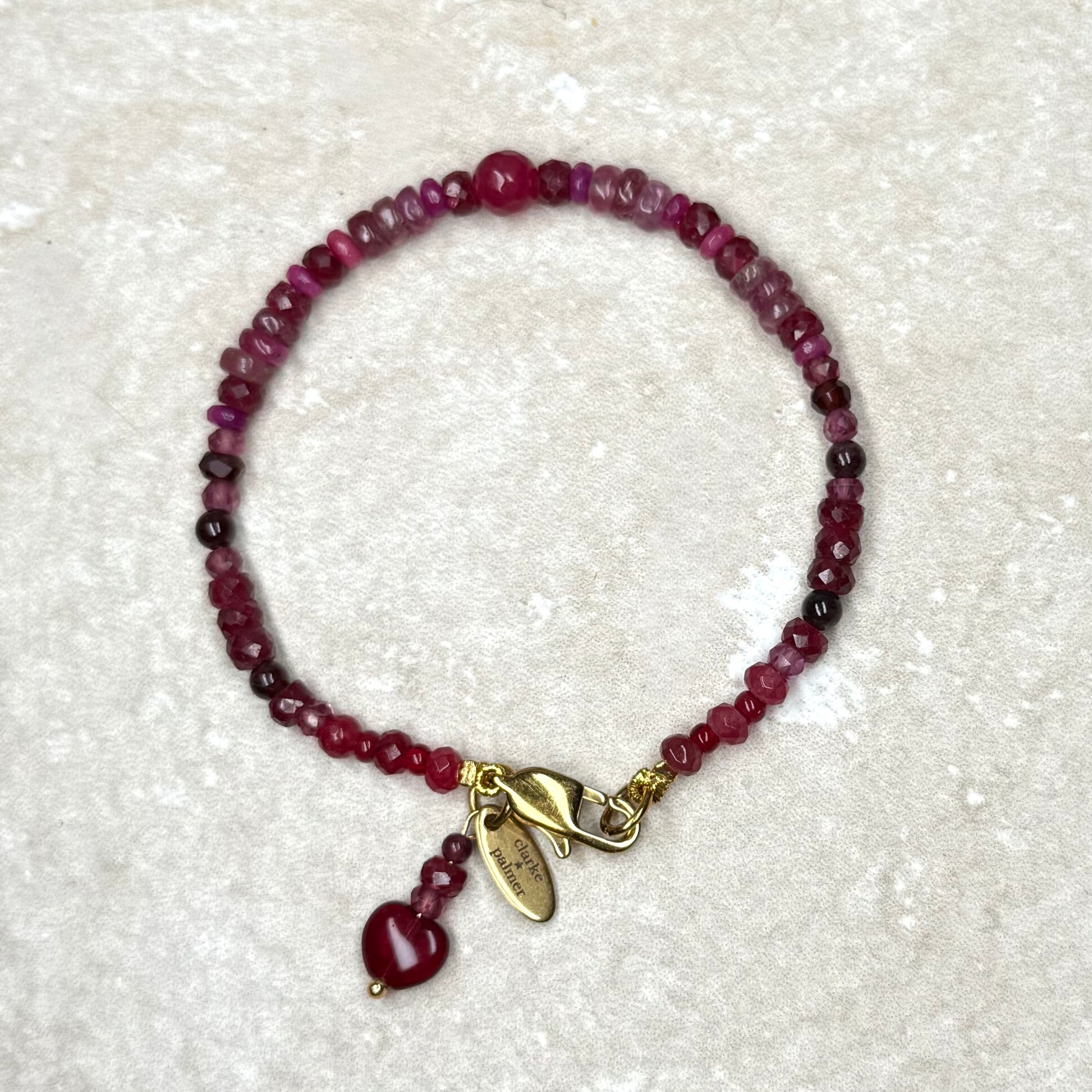 Clarke Palmer Root Chakra Red Gemstone Bracelet Flat Lay On Travertine Background 