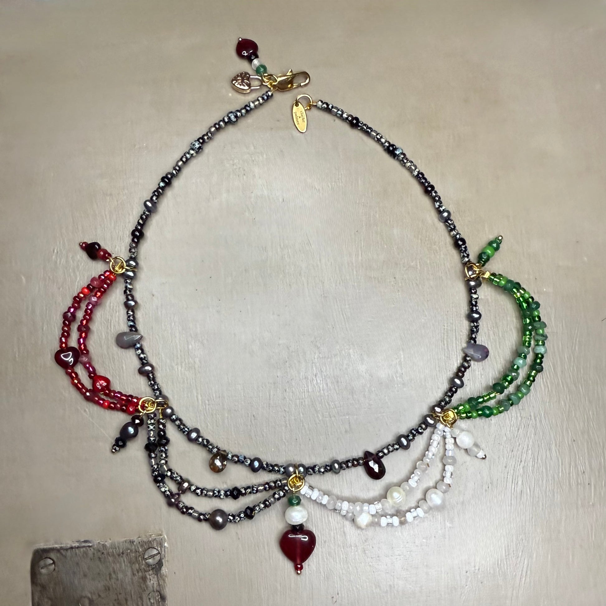 Multistrand beaded necklace with colorful gemstone beads on a neutral background