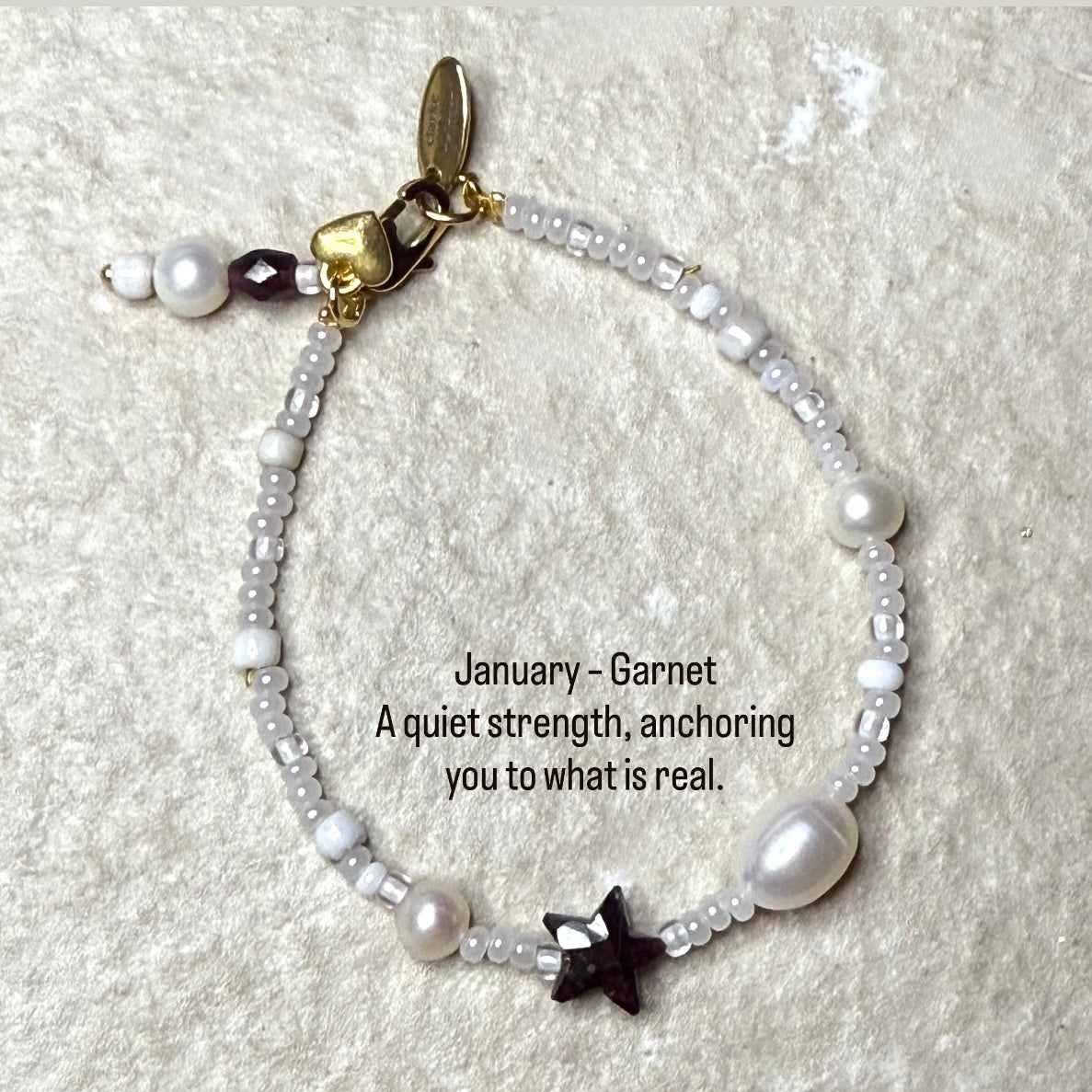Photo of Pearl & Garnet Star Bracelet with quote - January – Garnet
A quiet strength, anchoring you to what is real.