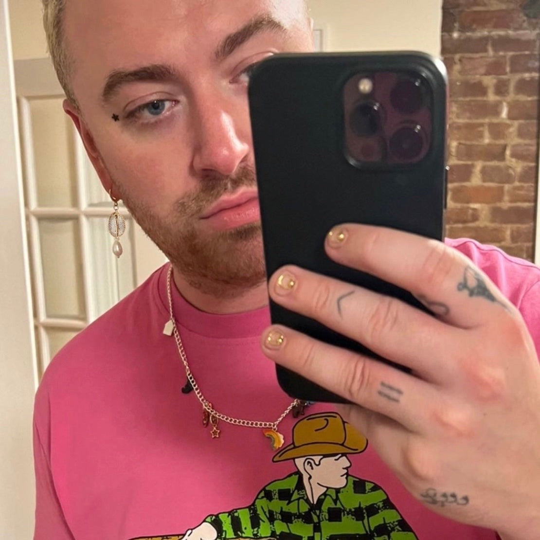 Sam Smith wearing Gold CZ cowrie shell earrings with pearl drops